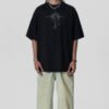 Man wearing a black oversized t-shirt with a dark rose graphic