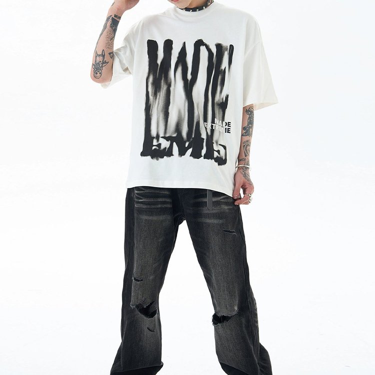 White oversized t-shirt with abstract black print and 'MADE ENTIRE' text