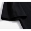 Close-up of the sleeve of a black oversized t-shirt with an acid wash effect.