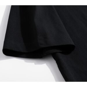 Close-up of the sleeve of a black oversized t-shirt with an acid wash effect.