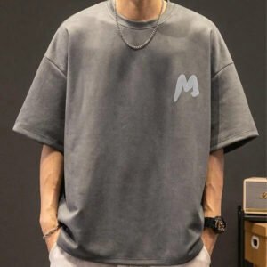 Grey oversized acid-wash t-shirt with a minimalist 'M' logo on the chest