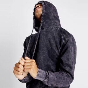 Man wearing a dark acid-wash pullover hoodie with hands clasped.