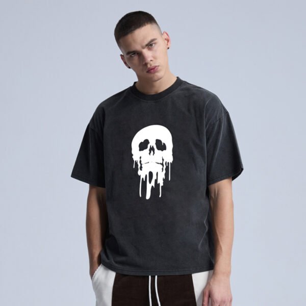 Man wearing a black acid-washed t-shirt with a white dripping skull graphic