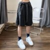 Custom Acid-Washed Relaxed Streetwear Shorts - Style 1E8770 Man wearing acid-washed dark utility shorts with drawstring waist.