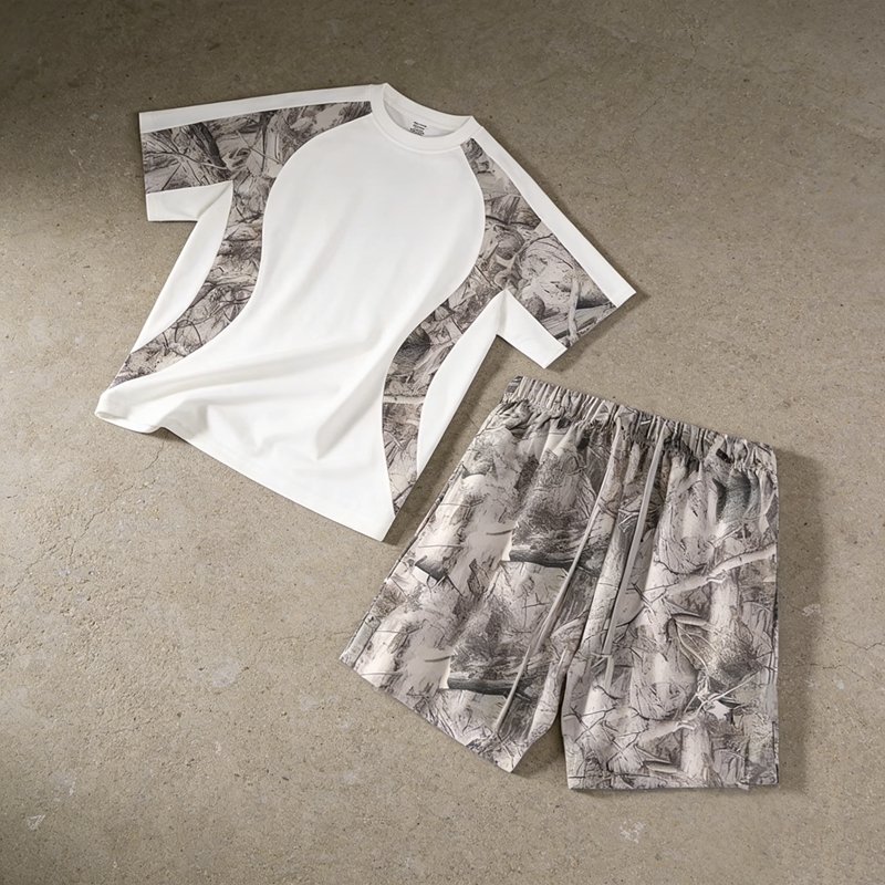 White t-shirt and shorts set with camouflage panel details.