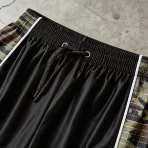 Close-up of black capri pants with camouflage side panels