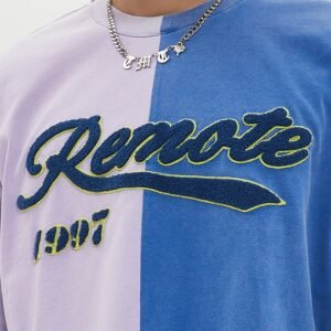 Close-up of a two-tone t-shirt with chenille applique text 'Remote 1997'