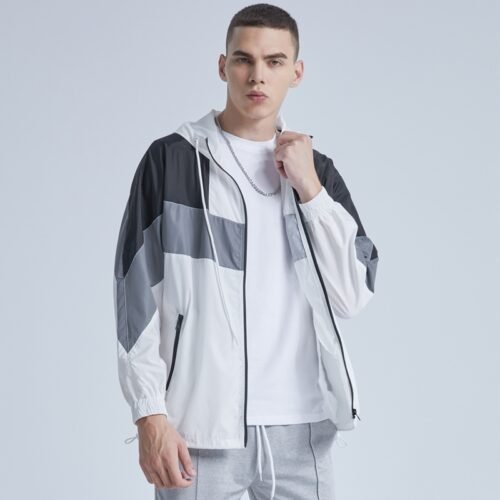 Man wearing a color-blocked zip-front hooded cardigan with grey, white, and black panels.