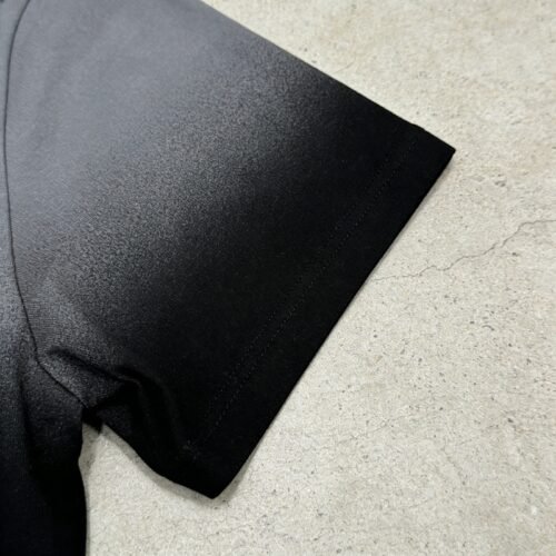 Close-up of a black and grey dip-dye polo shirt sleeve