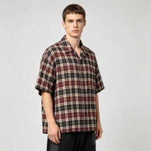 Man wearing a red, black, and green plaid short-sleeve collared shirt