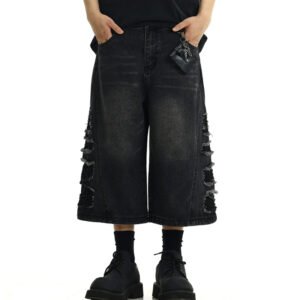 Man wearing distressed black denim long shorts with ripped details