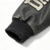 Close-up of a distressed black leather jacket sleeve with a ribbed cuff