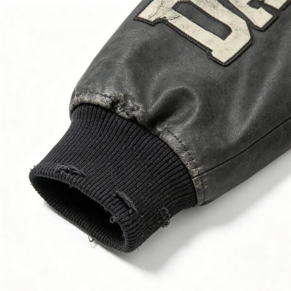 Custom Distressed Panel Varsity Jacket | VW-JK-256 - Style 256C06 Close-up of a distressed black leather jacket sleeve with a ribbed cuff