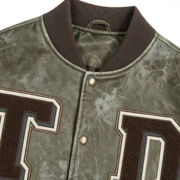 Custom Olive Distressed Varsity Jacket 710-11 - Style A58B74 Close-up of a custom olive distressed varsity jacket with embroidered letters