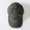Dark green distressed vintage wash baseball cap with holes.