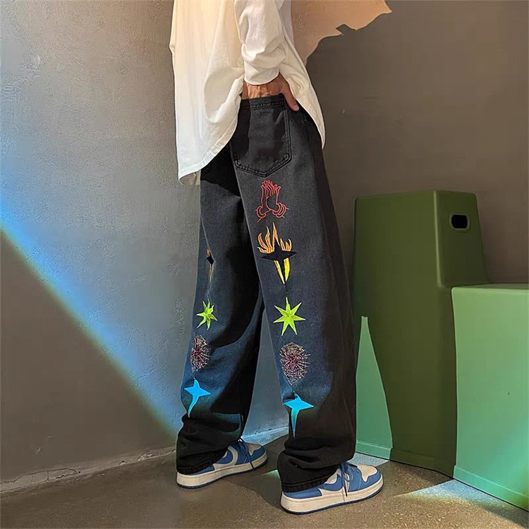 Mens black acid wash straight-leg jeans with embroidered graphics