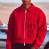 Red zip-up jacket with black embroidered abstract face and pinstripe detail