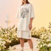 Custom Lightweight Streetwear Jersey Shorts - Style FC9743 Woman wearing a white graphic t-shirt and shorts in a floral setting.
