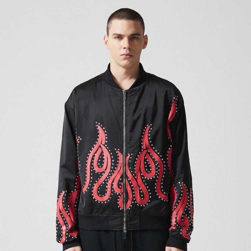 Man wearing a black bomber jacket with red flame embellishments and studs