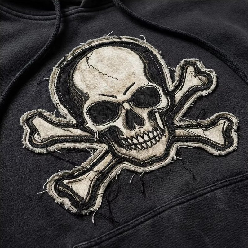 Black pullover hoodie with a frayed skull and crossbones applique