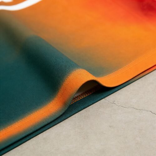Close-up of a custom gradient polo shirt with orange and green colors.