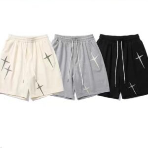 Three pairs of drawstring shorts in cream, grey, and black with cross graphics
