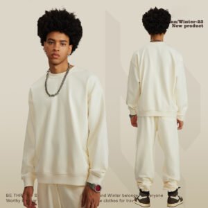 Man wearing a cream oversized cotton terry sweatshirt and matching sweatpants