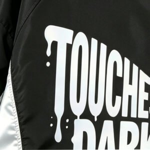 Close-up of a black hooded jacket with 'TOUCHES DARK' graphic print