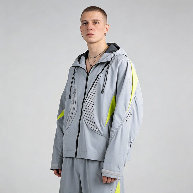Man wearing a grey hooded windbreaker with neon yellow accents