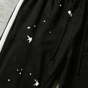 Black capri pants with white side stripe and ink splatter print