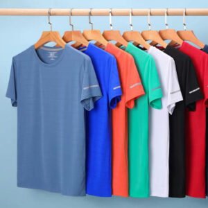 Multiple performance t-shirts in various bright colors hanging on a rack.