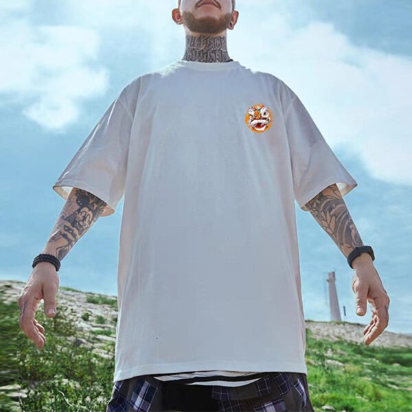 Man wearing an oversized white t-shirt with a small graphic emblem on the chest.
