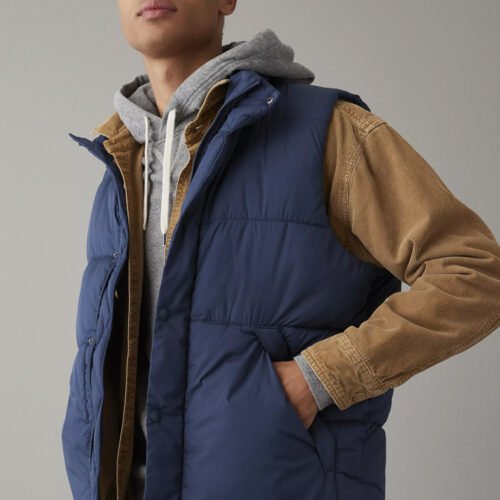 Custom Navy Quilted Puffer Vest - Style 5BEF9D Man wearing a navy quilted puffer vest over a grey hoodie and tan corduroy shirt.