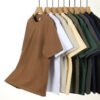 Row of oversized cotton t-shirts in various colors hanging on hangers.