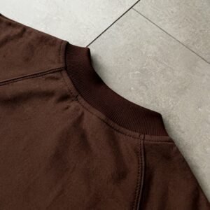 Close-up of a brown long-sleeve t-shirt collar and shoulder.