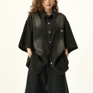 Woman wearing a black washed denim oversized short-sleeve collared shirt.