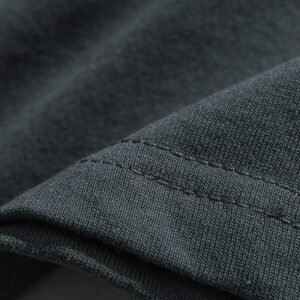 Close-up of the seam and fabric texture of a dark grey t-shirt.