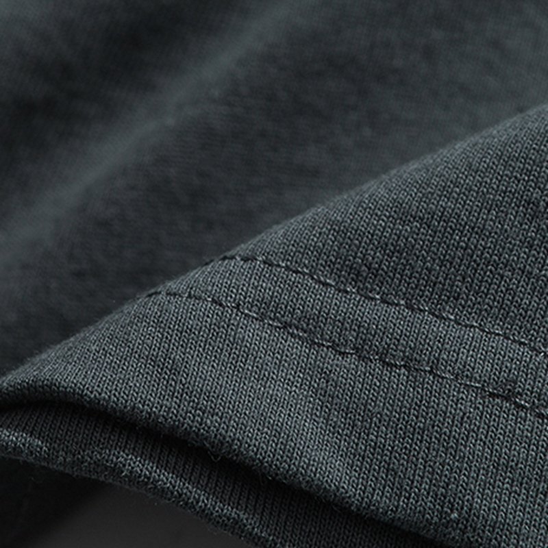 Close-up of the seam and fabric texture of a dark grey t-shirt.