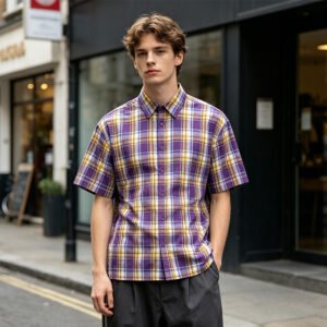 Man wearing an oversized purple and yellow plaid short-sleeve shirt.