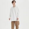 Man wearing a white oversized long-sleeve crew neck t-shirt.