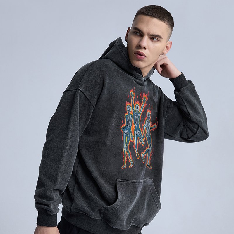 Man wearing a dark gray washed oversized graphic pullover hoodie with skeleton print