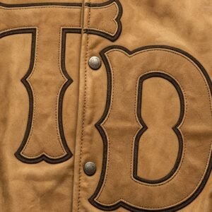 Close-up of a tan varsity jacket with TD lettering