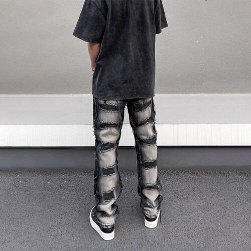 Men's dark wash distressed denim jeans with patchwork details.