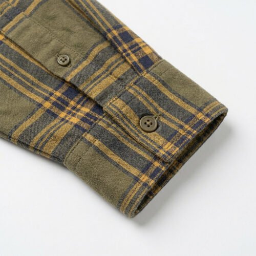 Close-up of an olive green plaid long-sleeve shirt cuff with buttons.