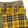 Close-up of green cargo pants with yellow plaid patchwork and a belted waist.