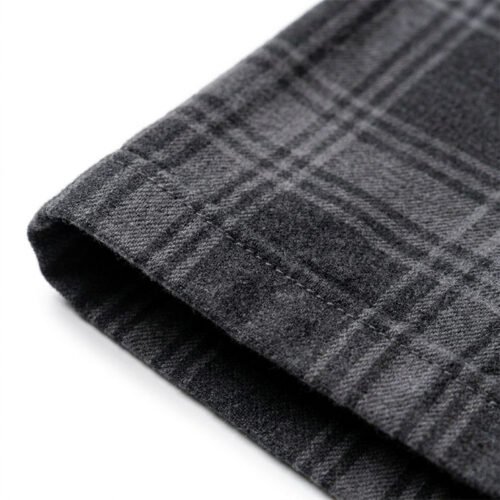 Close-up of the hem of a grey plaid short-sleeve overshirt