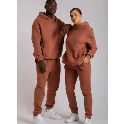 Unisex terracotta hoodie and jogger set worn by a male and female model