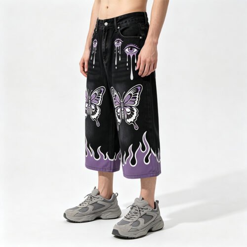 Man wearing black denim knee-length shorts with purple graphics