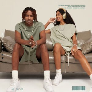 Couple wearing olive green vest and shorts set on a couch