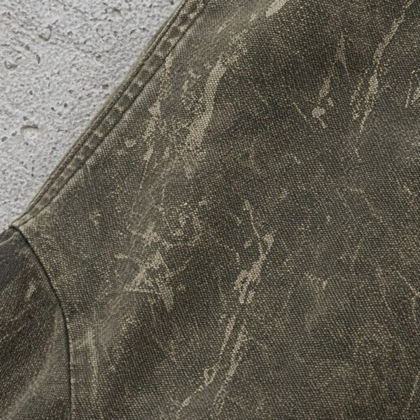 Custom Distressed Raw-Hem Hooded Canvas Jacket - Style C42448 Close-up of a distressed olive green hooded canvas jacket with a textured washed finish.